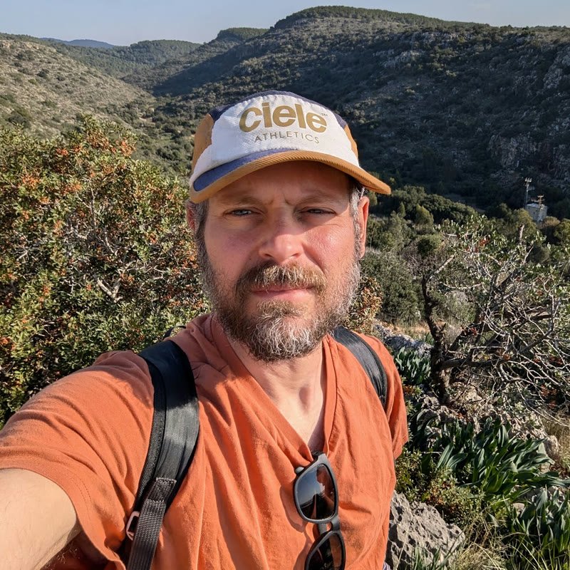 Michael Chein on a trail above a green valley